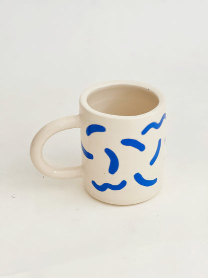The fun squiggles design adds a touch of whimsy to your cup of coffee or tea. Made by hand, this ceramic mug is durable and perfect for everyday use. Enjoy your favorite beverage in style with our unique Squiggles Mug.