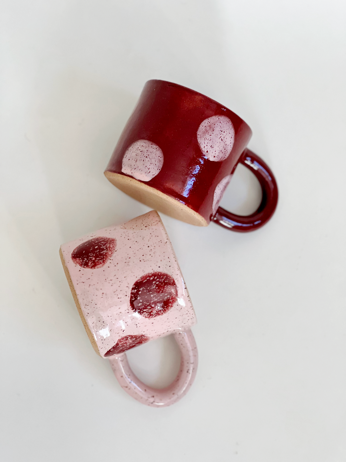 Two ceramic mugs with a speckled design on a white background
