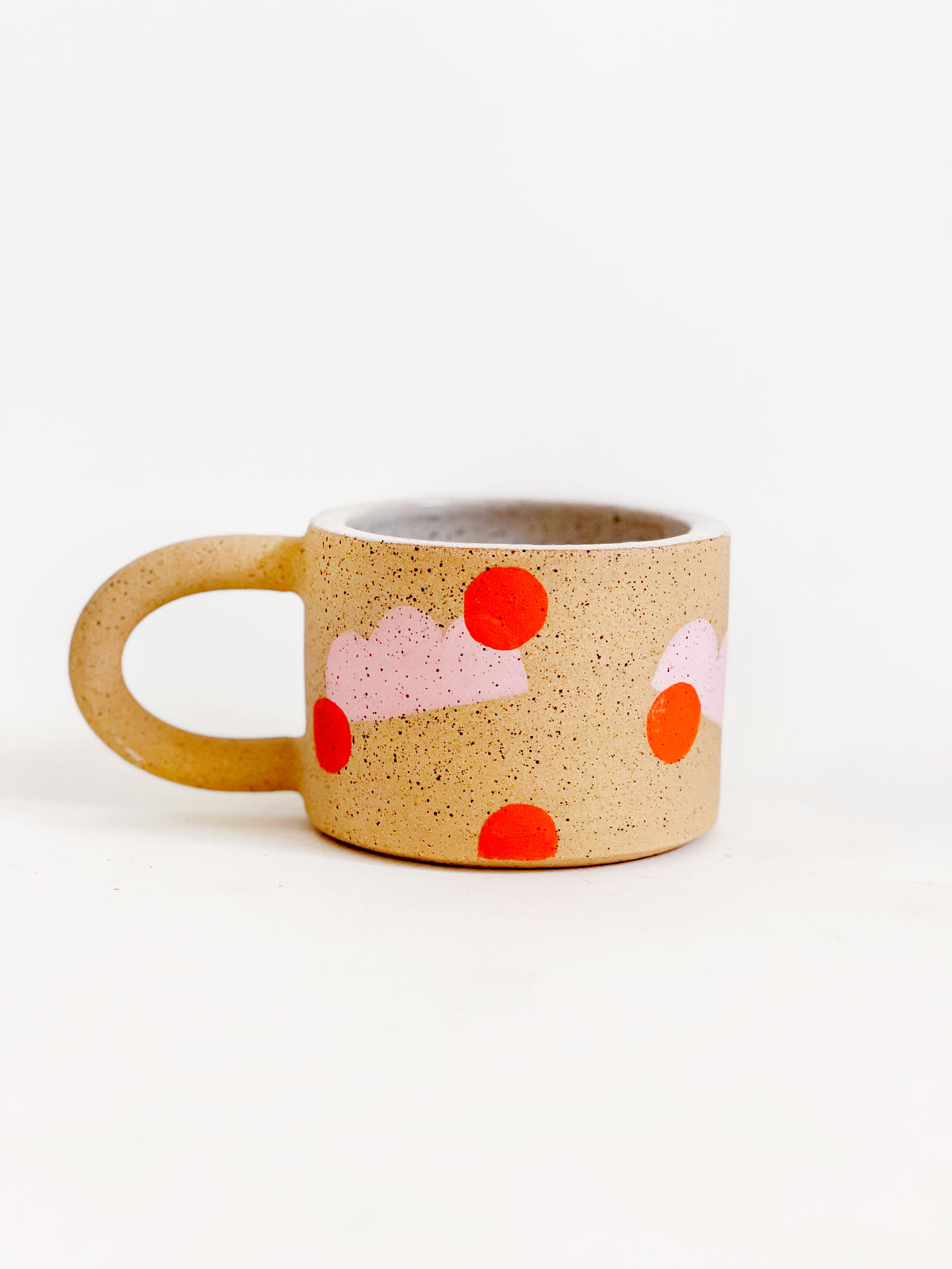 This handmade ceramic mug features playful polka dots over different shapes, adding a colorful and fun touch to your daily coffee or tea routine. Handcrafted with attention to detail, this unique mug is a must-have for any ceramic collection. Enjoy your favorite drink in a playful yet elegant way.
