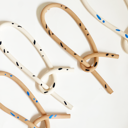 wall haning knots with black and blue pattern on a white background